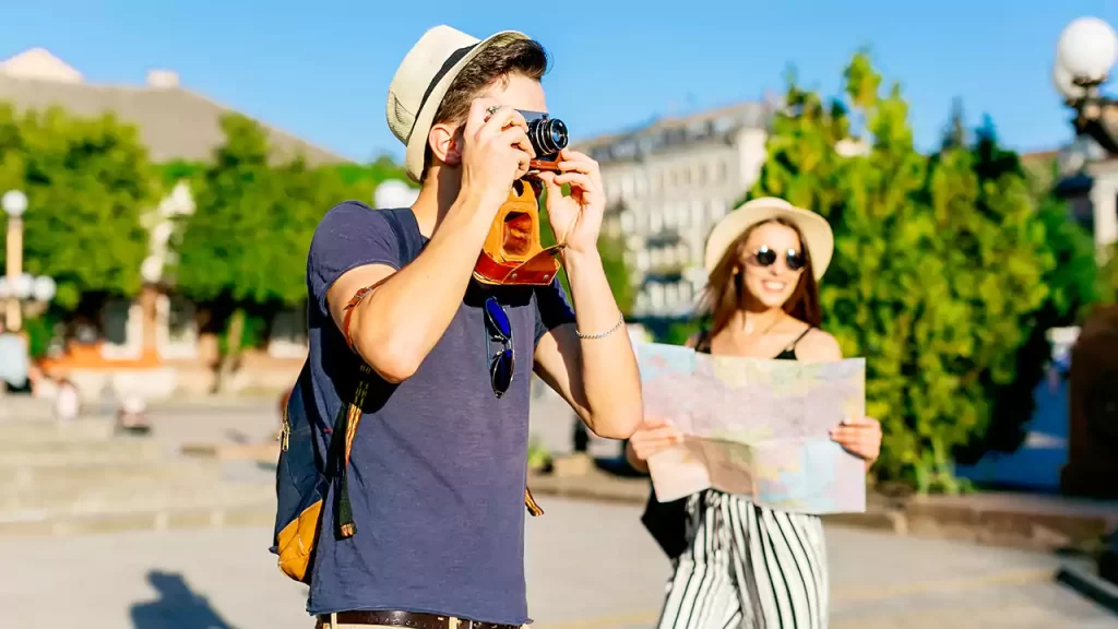 guy navigating travel destination and taking photo with girlfriend